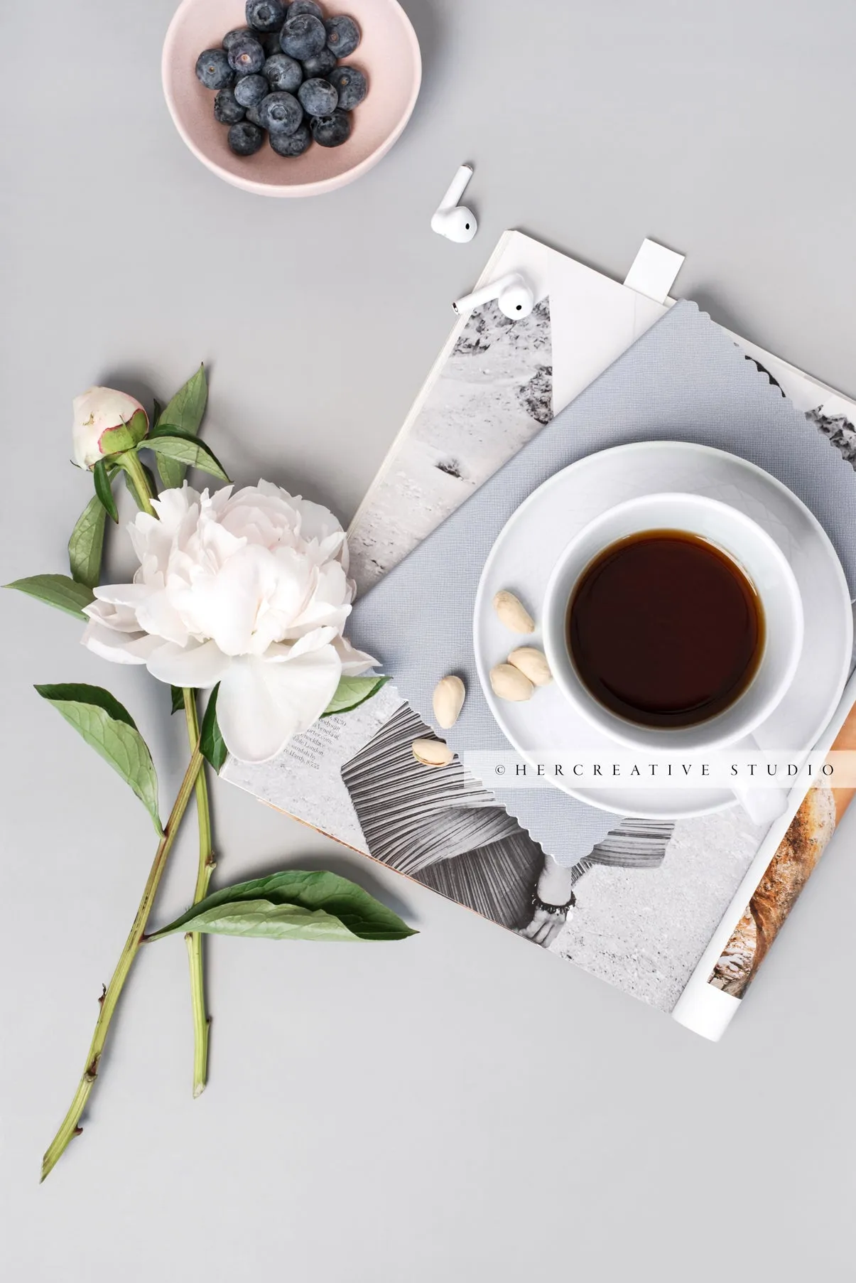 Peony, Berries and Earbuds on Grey Workspace. Stock Image